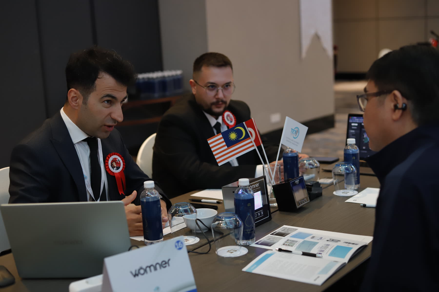 B2B meeting table with Malaysian and Turkish flags, Wömner devices on display