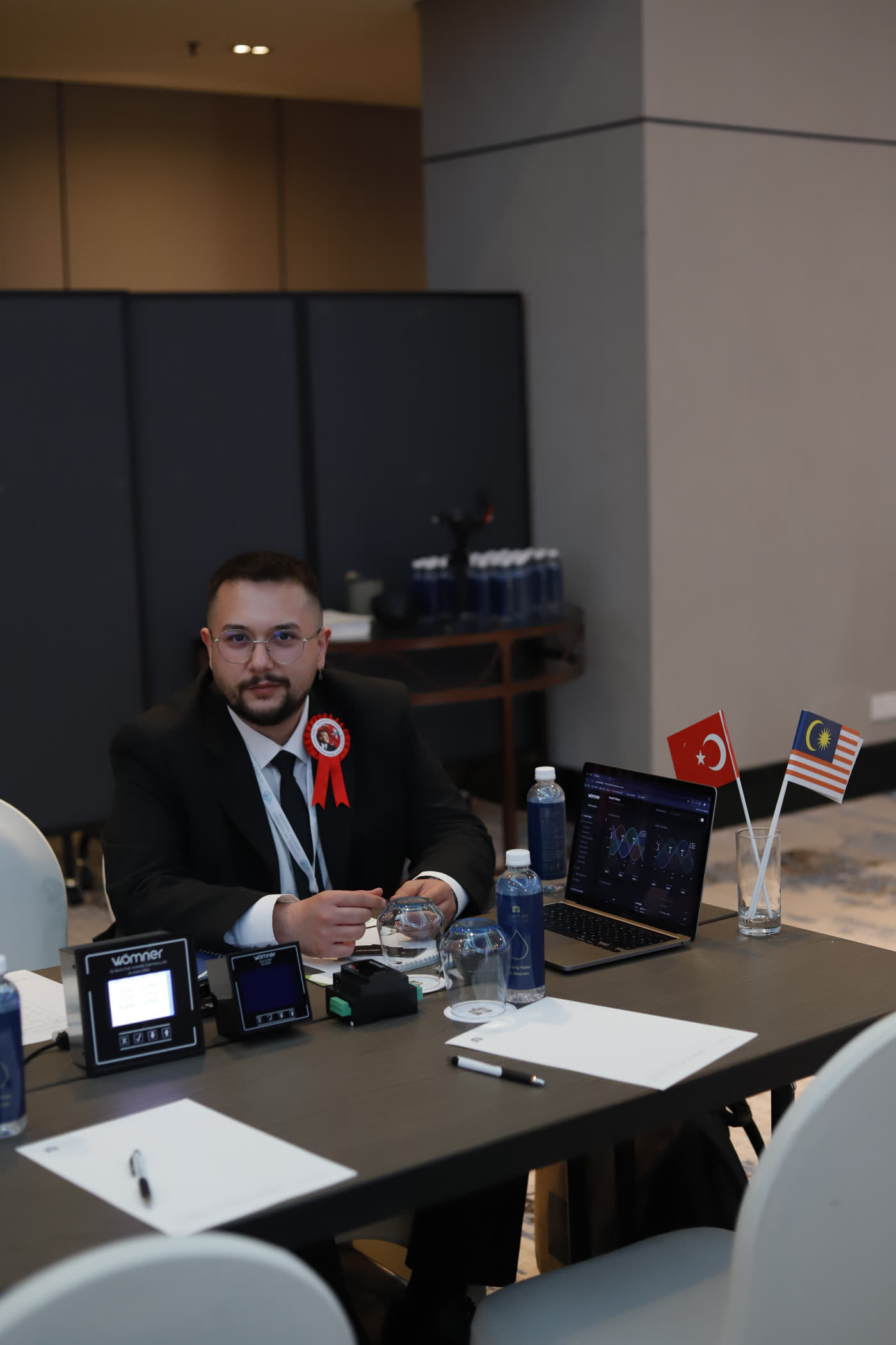 Mertcan Çakır at the Wömner table with live dashboards running, Kuala Lumpur